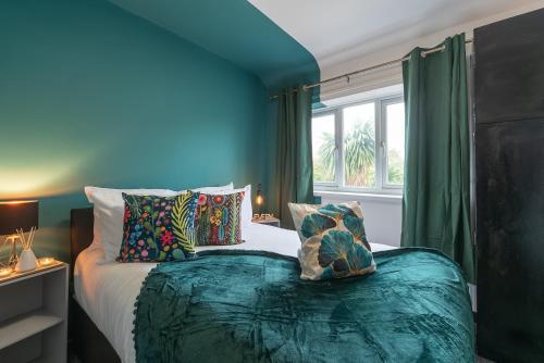 Habitación azul con cama y ventana en J's Home Away From Home FrEsH 2 Bedroom Garden Parking en Hull