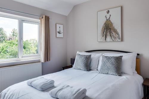 a bedroom with a large white bed with two windows at The Oxford Abode - 3-Bedroom House - large garden & free parking in Oxford