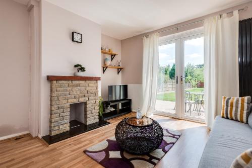 a living room with a couch and a fireplace at The Oxford Abode - 3-Bedroom House - large garden & free parking in Oxford