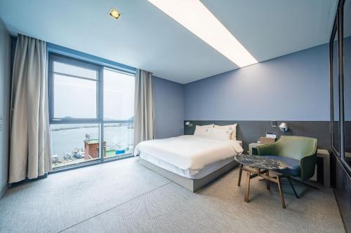 a bedroom with a bed and a large window at Louis Boutique Hotel in Changwon