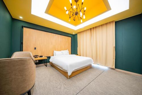 a hotel room with a bed and a chandelier at Louis Boutique Hotel in Changwon