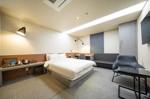 a hotel room with a bed and a chair at Louis Boutique Hotel in Changwon