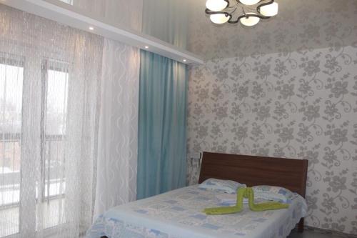 a bedroom with a bed with a yellow object on it at Apartamenty Svetlica Shamshinykh 90/5 studio in Novosibirsk