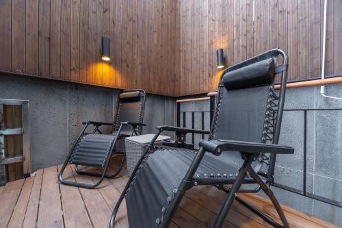 two rocking chairs sitting on a wooden deck at Louis Boutique Hotel in Changwon