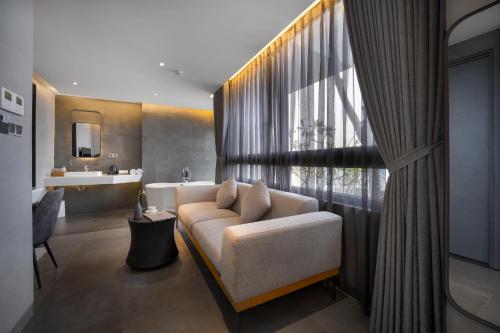 a living room with a couch and a large window at LEGEND Boutique Hotel in Da Nang