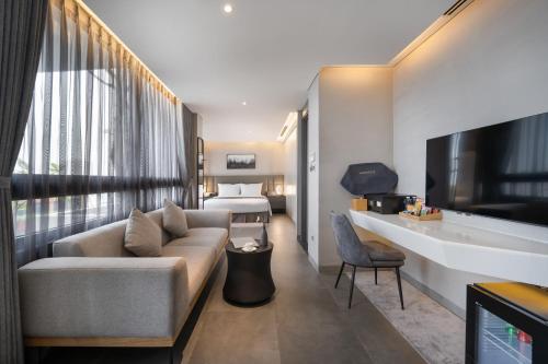 a hotel room with a couch and a bed at LEGEND Boutique Hotel in Da Nang