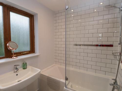 a bathroom with a shower and a sink and a tub at Ravenglass Retreat in Ravenglass
