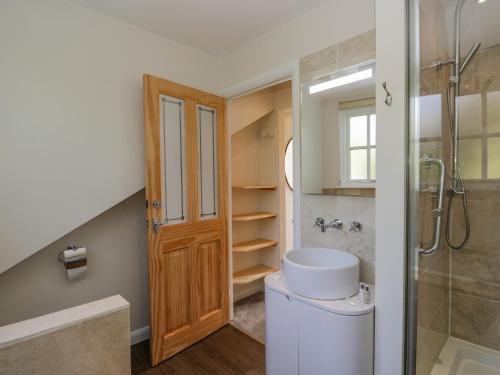 a bathroom with a shower and a toilet and a sink at Endgill Cottage in Ulverston