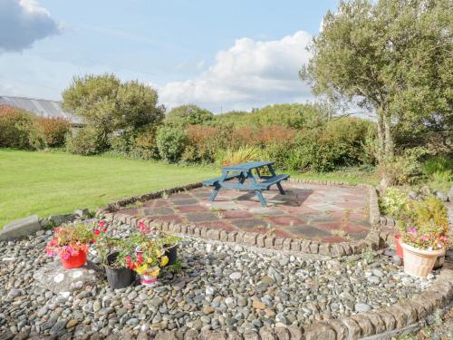 a blue picnic table on a stone patio with flowers at Ben View in Renvyle