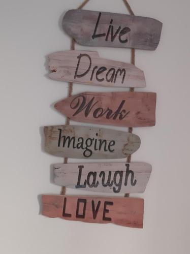 a wooden sign that reads live dream work imagine laugh love at Villa Sofia in Foz do Arelho