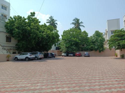 a parking lot with trees and cars parked at Beverly Hotel in Chennai