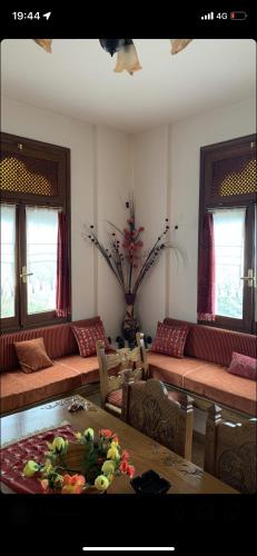 a living room with couches and a table in a room at Η θεα traditional house in Makrinítsa