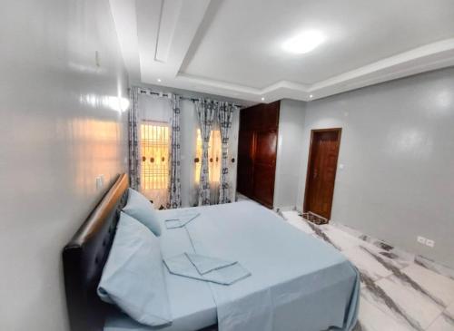 a bedroom with a blue bed in a room at Home Away From Home in Yaoundé