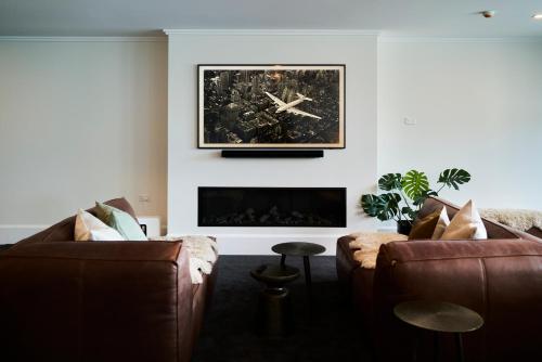 a living room with two couches and a fireplace at Laneway Apartments - The Residence in Napier