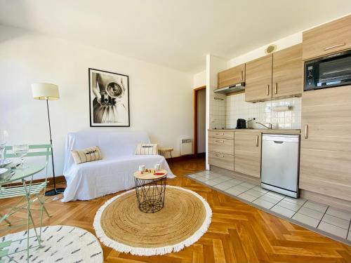 a kitchen and a living room with a table at Appartement Saint Claude - Centre Port in La Rochelle