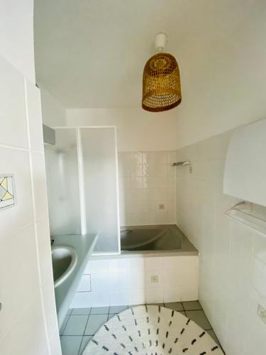 La salle de bains est pourvue d'un lavabo et d'une baignoire. dans l'établissement Appartement Saint Claude - Centre Port, à La Rochelle