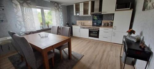 a kitchen with a wooden table and a dining room at Ferienwohnung am Brohlbach 