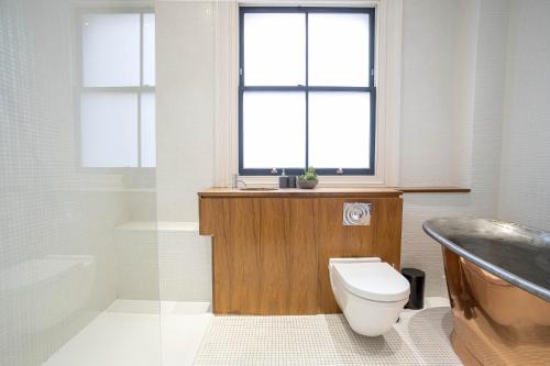 een badkamer met een toilet, een wastafel en een bad bij Liverpool St Three Bedroom Home near Tube Station in Londen