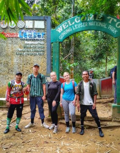 a group of people standing in front of a sign at Sumatra Orangutan Discovery Villa in Bukit Lawang