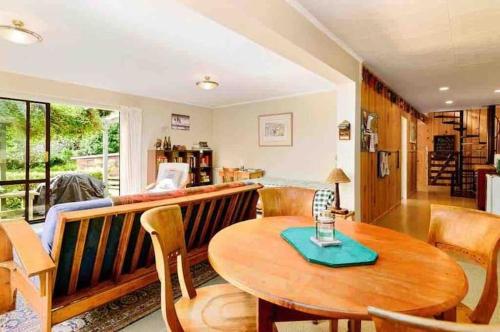 a living room with a wooden table and chairs at Paradise Valley River Lodge in Rotorua