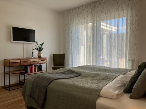 a bedroom with a bed and a window with a television at NEU - Premium-Ferienhaus MOSEL-SONNE in Traben-Trarbach