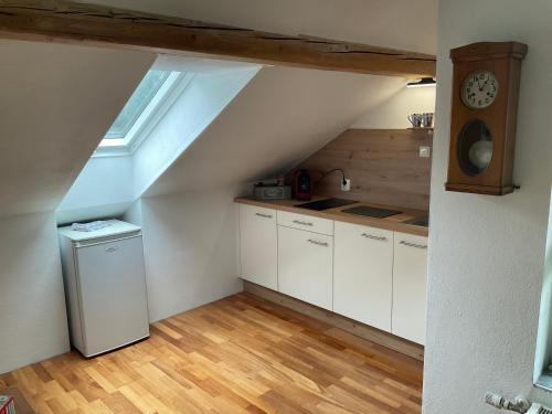a kitchen with white cabinets and a clock on the wall at Ferienwohnung Dallinger in Radmer an der Stube
