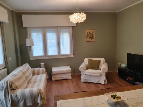 a living room with two chairs and a tv at Casa Botta. Ampio appartamento luminoso e confortevole in Morbegno