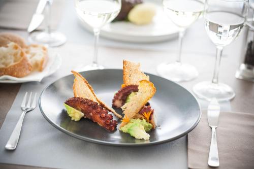 a plate of food on a table with wine glasses at Hotel Torino Wellness & Spa in Diano Marina