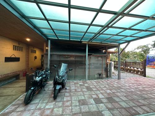 two motorcycles parked in a building with a garage at Ying Tian Ye Homestay in Jian