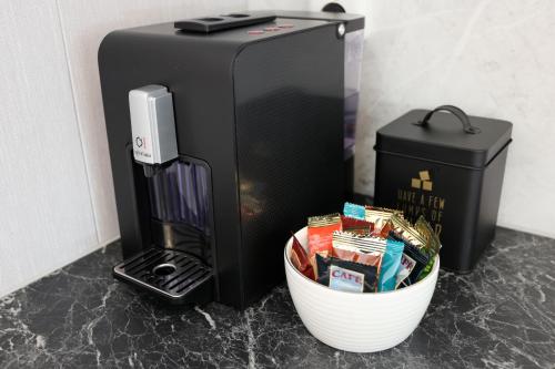 a black refrigerator and a bowl of snacks next to a container at B&B Schoonhoven Suites in Elim