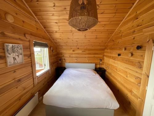 een slaapkamer in een blokhut met een bed erin bij Vrådal Panorama in Sinnes