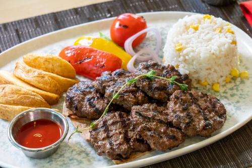 a plate of food with meat and rice and bread at ibis Adana in Adana