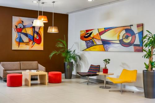 a lobby with colorful furniture and paintings on the wall at ibis Adana in Adana
