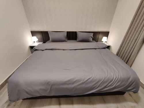 um quarto com uma cama grande e 2 almofadas em 43m luxury room near downtown and all services em Amã