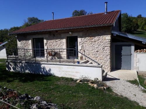 ein kleines Steinhaus mit einem Hund auf dem Balkon in der Unterkunft Gîte de Saint-Christophe 