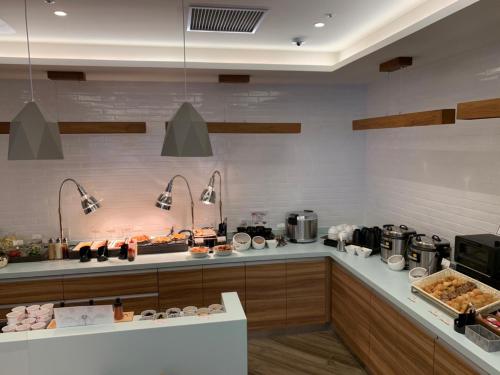 a kitchen with a counter with food on it at Smile Hotel Hiroshima in Hiroshima