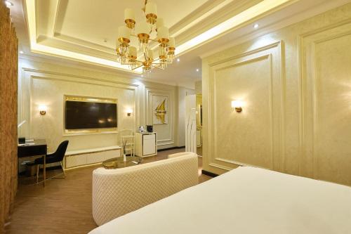 Habitación con cama, mesa y lámpara de araña. en East Star Hotel en Samarcanda