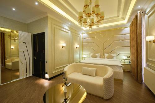 a bedroom with a bed and a couch and a chandelier at East Star Hotel in Samarkand