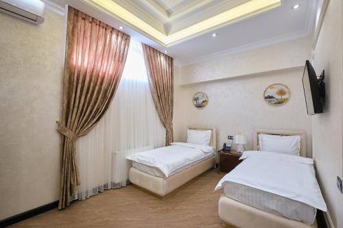 a hotel room with two beds and a window at East Star Hotel in Samarkand