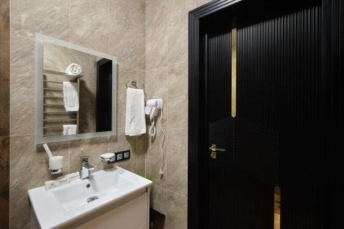 a bathroom with a sink and a mirror at East Star Hotel in Samarkand