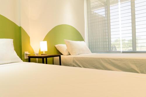 a bedroom with two beds and a window at Manta Dream Resort in Panglao