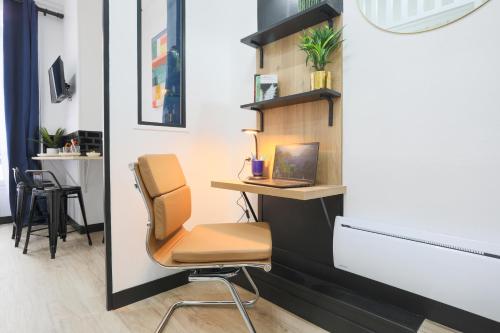 Cette chambre dispose d'un bureau avec une chaise et un ordinateur portable. dans l'établissement WS Opéra - Sainte-Anne, à Paris