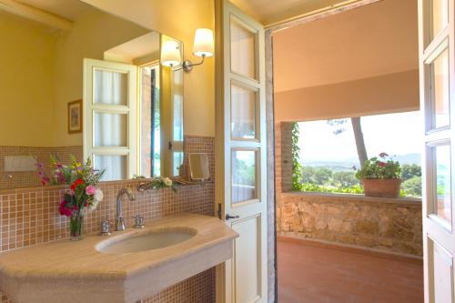 baño con lavabo, espejo y ventanas en Fattoria di Magliano Winery en Magliano in Toscana