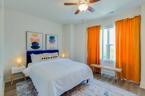 a bedroom with a white bed and orange curtains at #BestStayEverNashville in Nashville