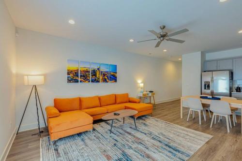 a living room with an orange couch and a dining room at #BestStayEverNashville in Nashville