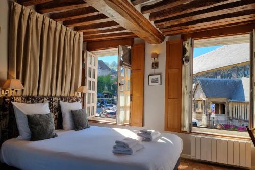 um quarto com uma cama grande e uma janela grande em Chambres Houdaille em Honfleur