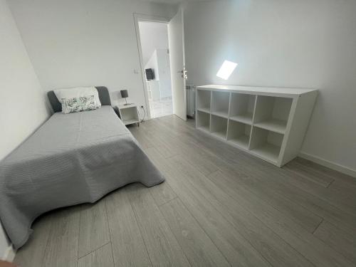 a white bedroom with a bed and a wooden floor at Barcelos Views in Barcelos