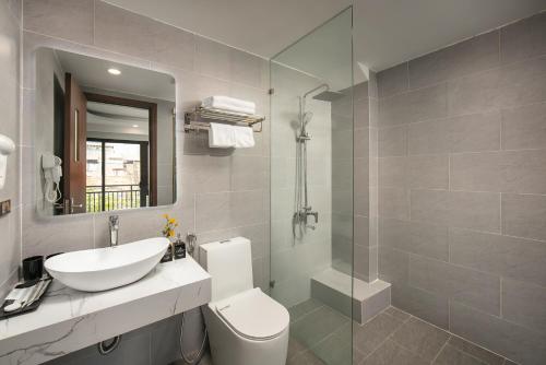 La salle de bains est pourvue d'un lavabo, de toilettes et d'un miroir. dans l'établissement Hanoi Vacanza Premier Hotel, à Hanoï