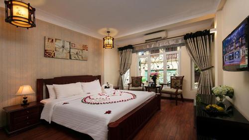 Кровать или кровати в номере Khách Sạn Thủ Đô Formerly Impressive Hotel