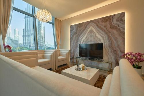 a living room with a couch and a flat screen tv at Magnificent 3 BR Luxury Apartment with Burj Khalifa View in Dubai